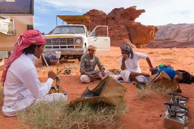 a group of people sitting in the desert at Wadi Rum Nature Tours And Camp in Wadi Rum