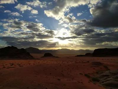 a view of the desert under a cloudy sky at Wadi Rum Nature Tours And Camp in Wadi Rum