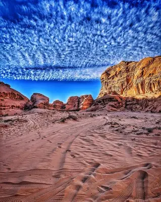 a view of a desert with rocks and a cloudy sky at Wadi Rum Lawrence Camp in Wadi Rum