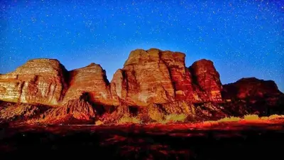 a view of a rock formation in the desert at night at Wadi Rum Lawrence Camp in Wadi Rum