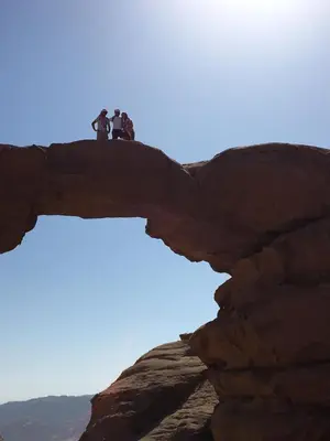 two people standing on top of a rock formation at Wadi Rum Lawrence Camp in Wadi Rum