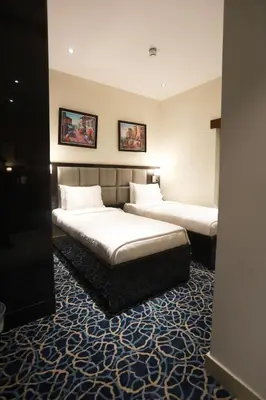 a hotel room with two beds and two pictures on the wall at Naylover Hotel Suites in Amman
