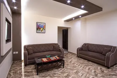 a living room with two brown couches and a coffee table at Al Riyati Hotel Apartments in Aqaba