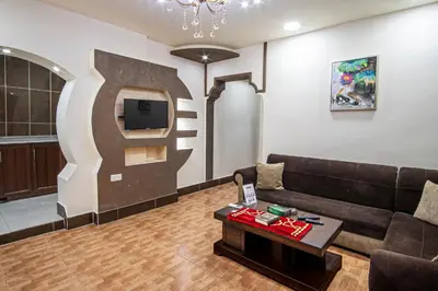 a living room with a couch and a tv at Al Riyati Hotel Apartments in Aqaba