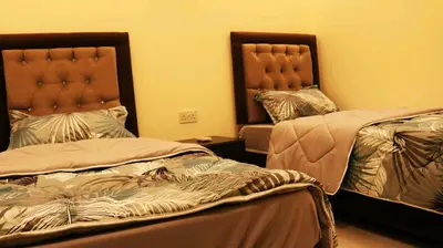 two beds in a hotel room with two bedsskirts at Al Riyati Hotel Apartments in Aqaba