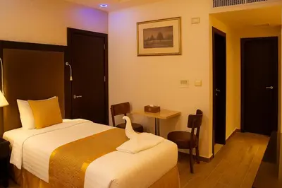 a hotel room with a bed and a table at Aljamal Hotel in Amman
