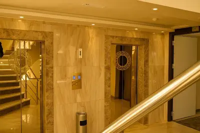 a lobby with a staircase and a stair case at Aljamal Hotel in Amman
