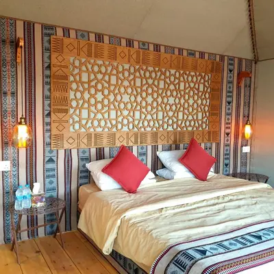 a bedroom with a large bed with red pillows at Captains Desert Camp in Wadi Rum