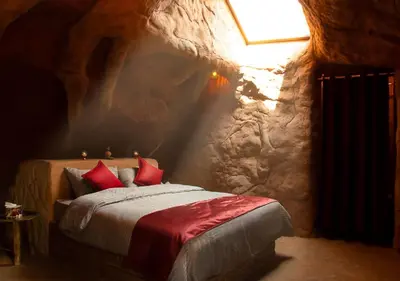 a bedroom with a bed in a stone cave at Captains Desert Camp in Wadi Rum