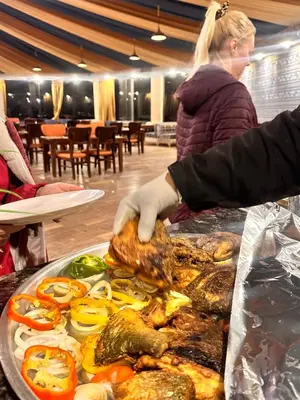 a woman is preparing a tray of food on a table at Panorama Wadi Rum in Wadi Rum