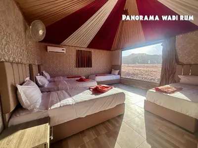 a bedroom with two beds and a red tent at Panorama Wadi Rum in Wadi Rum