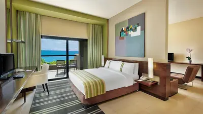 a bedroom with a bed and a desk and a television at Holiday Inn Resort Dead Sea by IHG in Sowayma