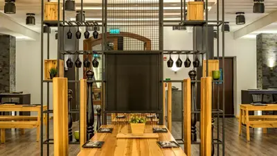 a room with wooden tables and utensils at Holiday Inn Resort Dead Sea by IHG in Sowayma