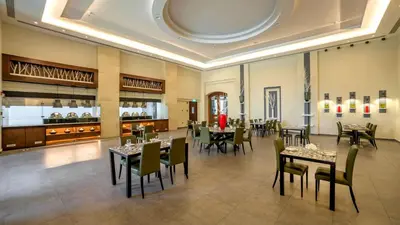 a restaurant with tables and chairs in a room at Holiday Inn Resort Dead Sea by IHG in Sowayma