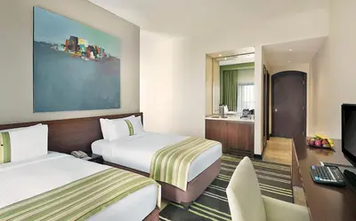 a hotel room with two beds and a desk at Holiday Inn Resort Dead Sea by IHG in Sowayma