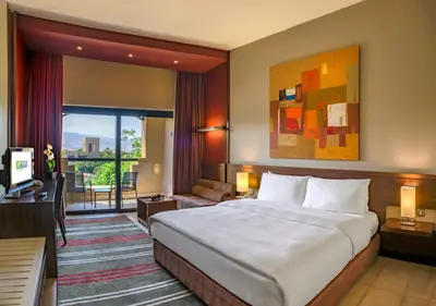 a hotel room with a bed and a balcony at Holiday Inn Resort Dead Sea by IHG in Sowayma