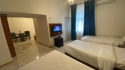 a hotel room with two beds and a television at New Park Hotel in Amman