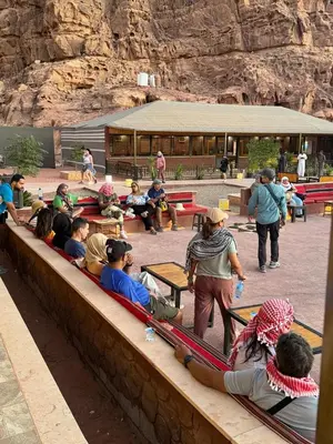 a group of people sitting in front of a building at Beauty Wadi Rum Luxury Camp in Wadi Rum