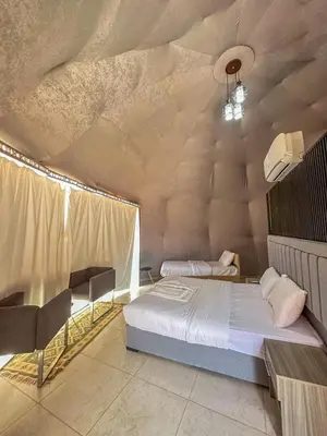 a bedroom with a bed in a room with a ceiling at Beauty Wadi Rum Luxury Camp in Wadi Rum