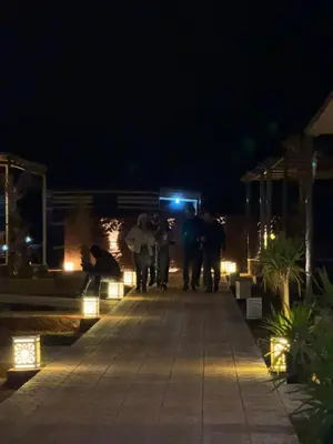 a group of people walking down a walkway at night at Beauty Wadi Rum Luxury Camp in Wadi Rum