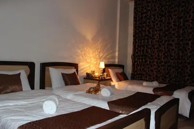 a hotel room with two beds and a lamp at Arab Tower Hotel in Amman