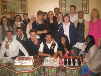 a group of people posing for a picture with a cake at Arab Tower Hotel in Amman
