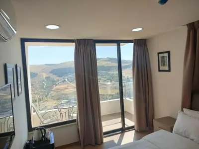 a bedroom with a bed and a large window at Sindyan Resort in Amman