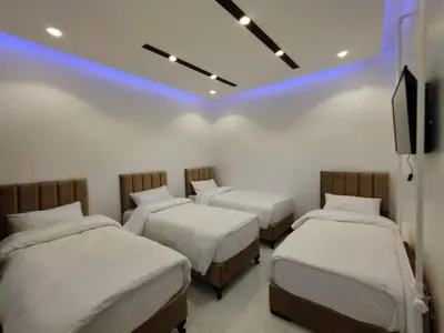 a room with three beds and a tv in it at Mussa Spring Hotel in Wadi Musa
