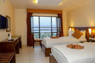 a hotel room with two beds and a window at City Tower Hotel in Aqaba