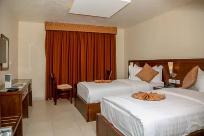 a hotel room with two beds and a desk at City Tower Hotel in Aqaba