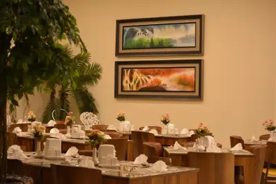 a dining room with tables and chairs and a painting on the wall at City Tower Hotel in Aqaba