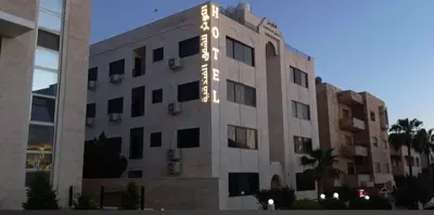 a building with lights on the side of it at Al Kawther Hotel Apartments in Amman