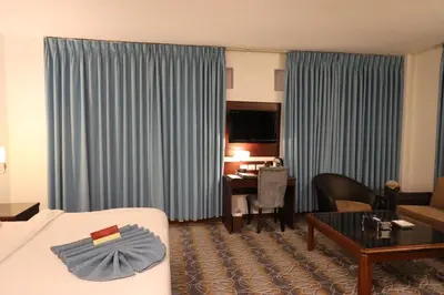 a hotel room with a bed and a table and a desk at Larsa Hotel in Amman