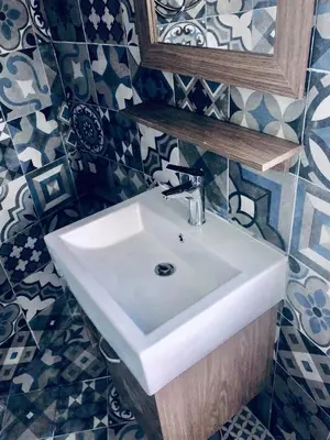 a bathroom with a white sink and a mirror at Jordan Tower Hotel in Amman