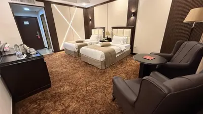 a hotel room with a bed and a couch and chairs at Rojina Hotel in Amman