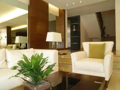 a living room with a white couch and a chair at Granada Suites Hotel in Amman