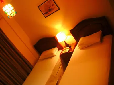 two beds in a room with two lamps on them at Al Rashid Hotel in Wadi Musa
