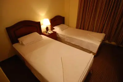 a hotel room with two beds and a lamp at Al Rashid Hotel in Wadi Musa