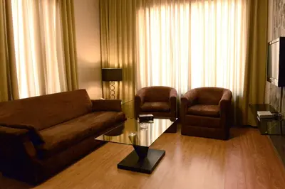 a living room with a couch and two chairs at Crystal Suites in Amman