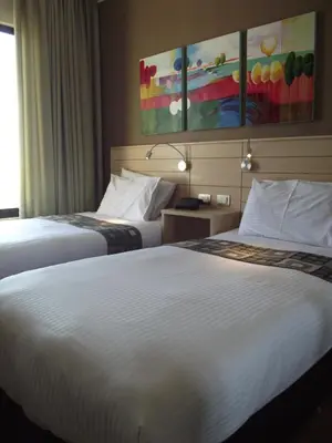 a hotel room with two beds and a painting on the wall at Crystal Suites in Amman