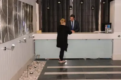 a woman standing at a counter in front of a man at Crystal Suites in Amman