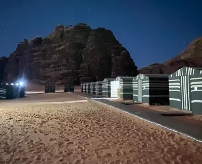 a mountain in the middle of a desert at night at Wadi Rum Jordan Camp in Wadi Rum
