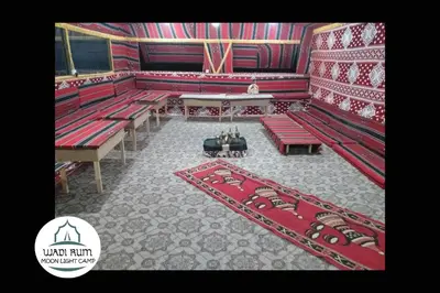 a large auditorium with red benches and a rug at Wadi Rum Moon Light Camp in Wadi Rum