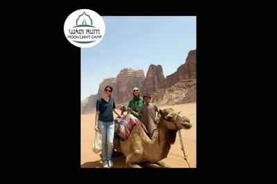 a group of people riding a camel in the desert at Wadi Rum Moon Light Camp in Wadi Rum