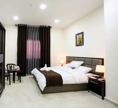 a bedroom with a large bed and a desk at 7Boys Hotel in Amman