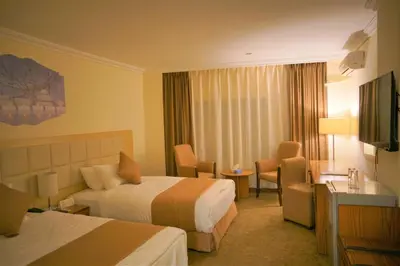 a hotel room with two beds and a television at Silk Road Hotel in Wadi Musa