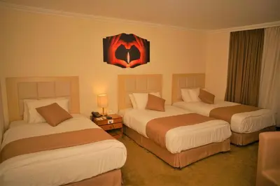 a hotel room with two beds with a batman picture on the wall at Silk Road Hotel in Wadi Musa