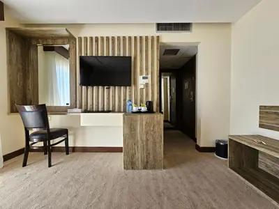a hotel room with a chair and a flat screen tv at Edom Hotel in Wadi Musa