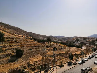 a road with cars parked on the side of a hill at Sunset Hotel in Wadi Musa