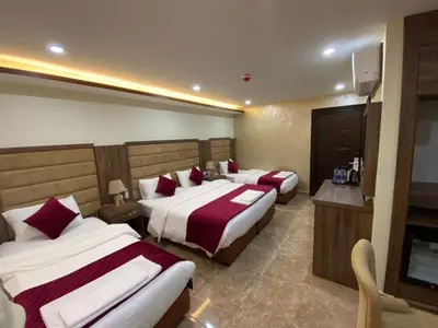 a hotel room with two beds and a television at Sunset Hotel in Wadi Musa